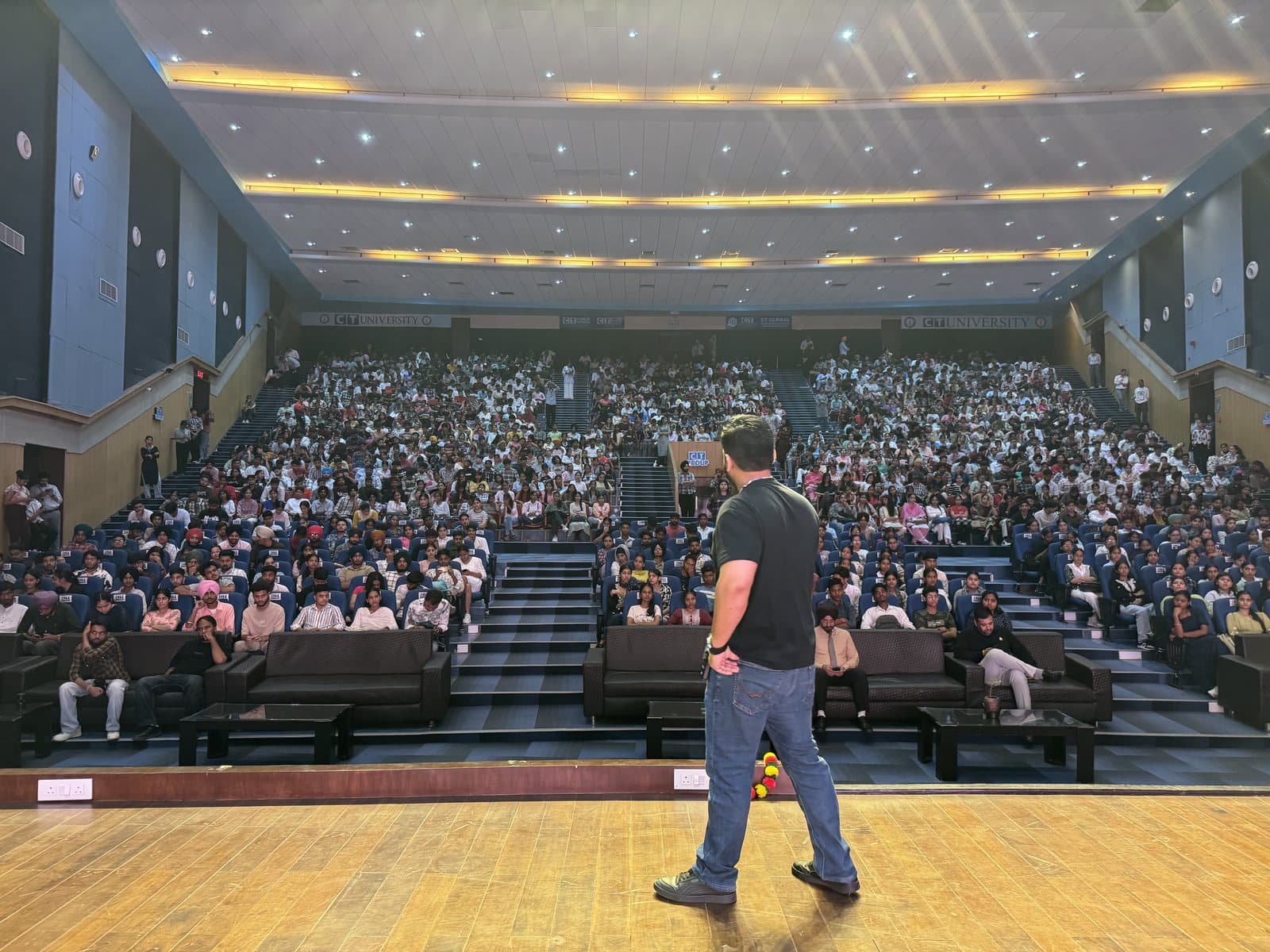 Gourav Gupta addressing a full hall of students from the stage