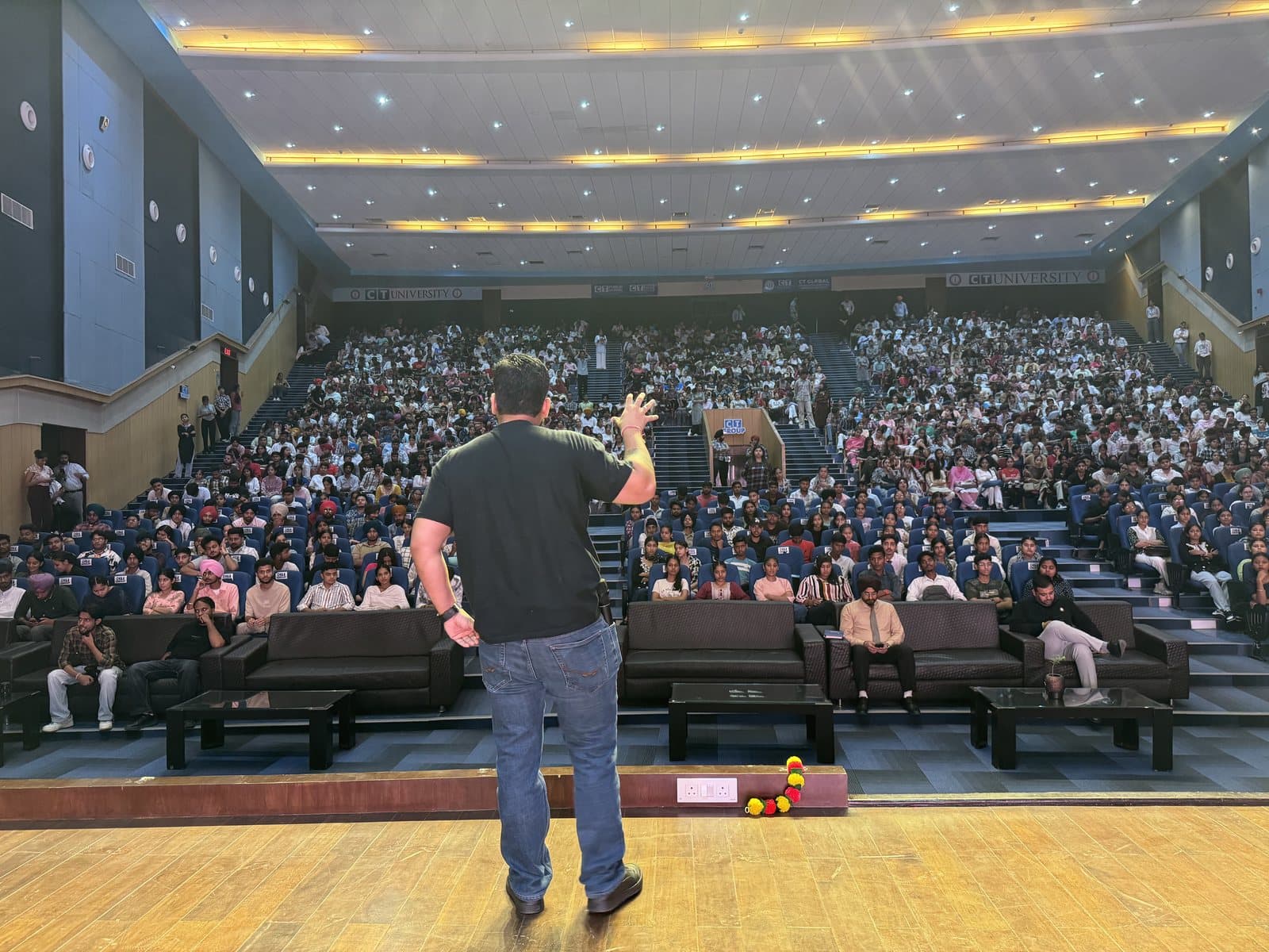 Gourav Gupta raising his hand to the audience during a talk